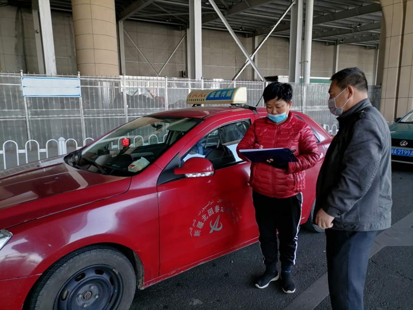 圖為：運(yùn)輸公司管理人員在高鐵站檢查所屬出租車處在消毒情況_副本.jpg